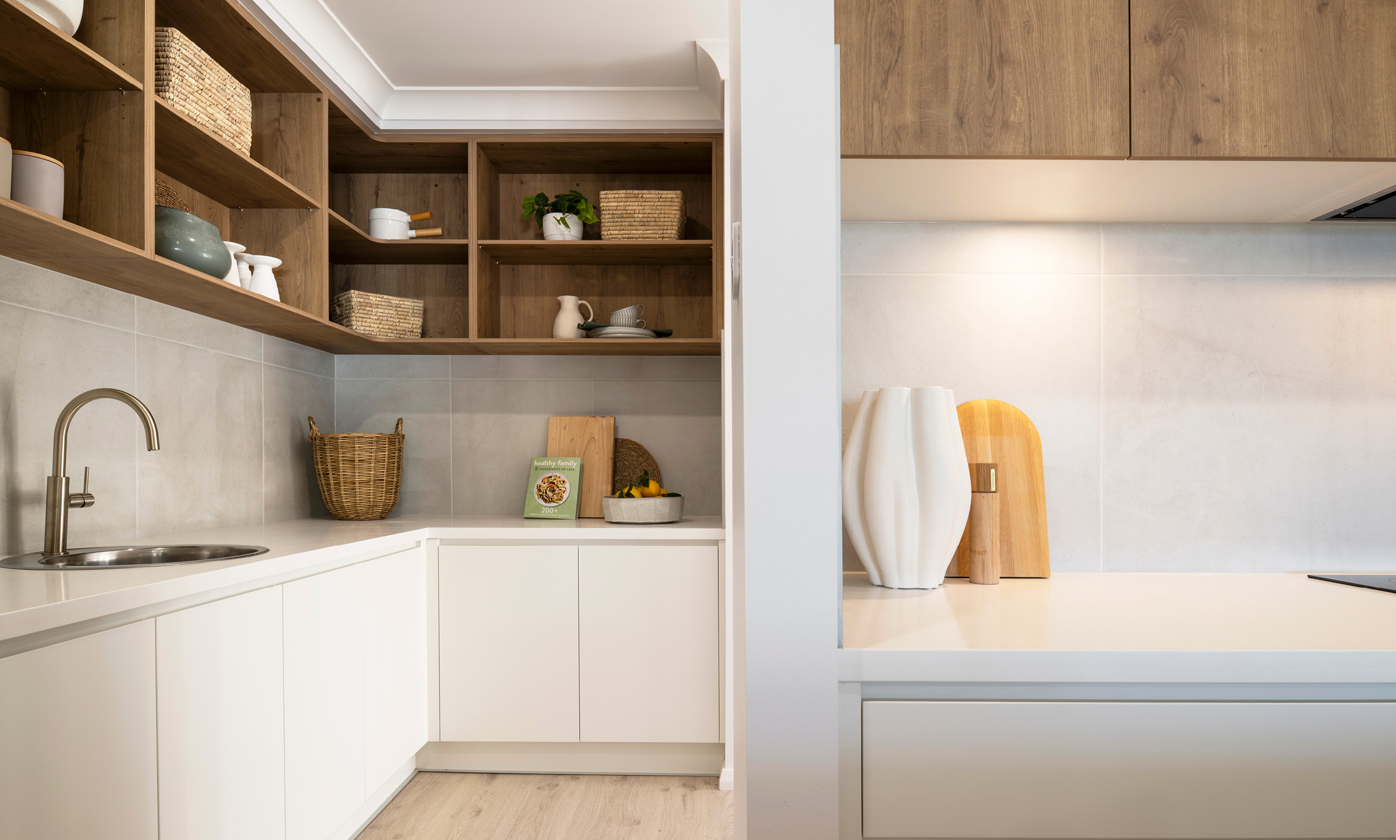 Butler's pantry with white and warm timber cabinetry. Brushed nickel tapware and round sink.