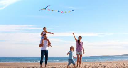 family at beach flying kite.